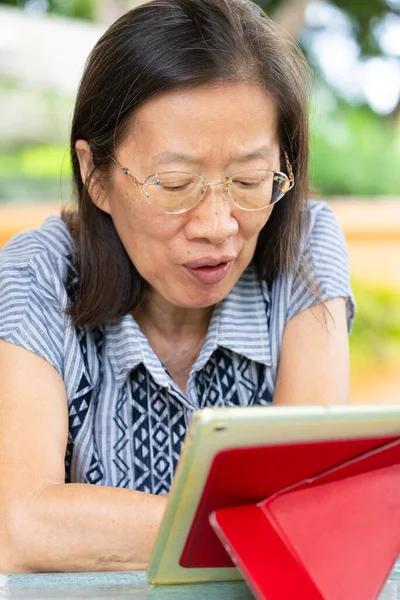 Sênior Mulher Asiática Usando Tablet Digital Para Ler Mídias Sociais — Fotografia de Stock