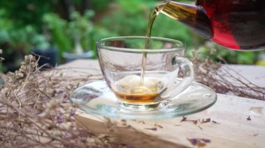 Kafedeki masada servis edilen çay fincanına sıcak çay döküldü.