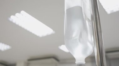 Hastanede direğe asılı salin torbasını kapatın.