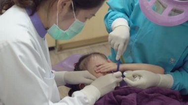 Diş sağlığı kliniğindeki Asyalı kıza florür tedavisi uyguladığını gösteren yakın görüş.