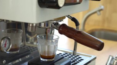 İnsanlar kahve makinesi kullanarak sıcak espresso yapıyorlar.