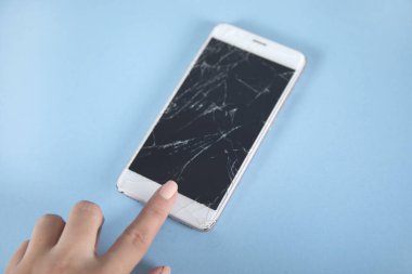 Kırık telefon ekranına dokunan kadın