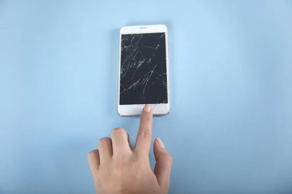woman touching broken phone screen