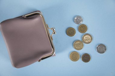 Bozuk paralar ve cüzdan mavi masada.