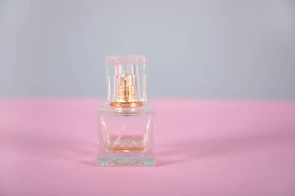 women\'s perfume on the pink table