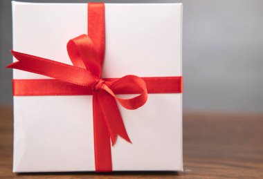 Tahta masanın üzerindeki beyaz hediye kutusu.