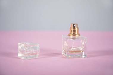 Pembe arka planda bir şişe parfüm.