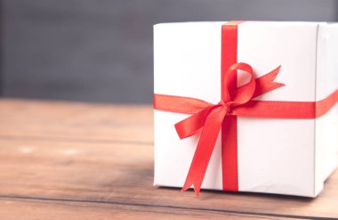 Tahta masanın üzerindeki beyaz hediye kutusu.