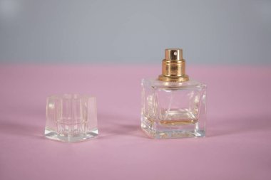 Pembe arka planda bir şişe parfüm.