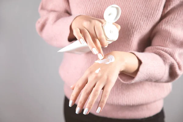 Jonge Vrouw Hand Crème Grijze Achtergrond — Stockfoto