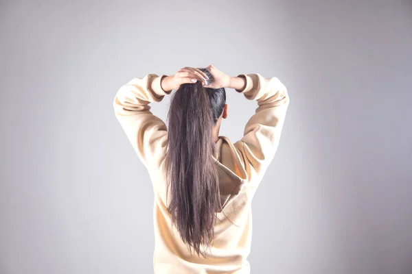 Jeune Femme Pour Attacher Les Cheveux Sur Fond Gris — Photo