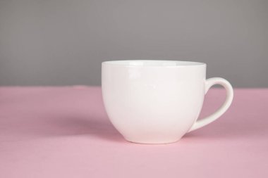 Pembe masanın arkasında bir fincan kahve.