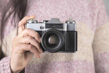 Klasik fotoğraf makinesini tutan genç bir kadın..