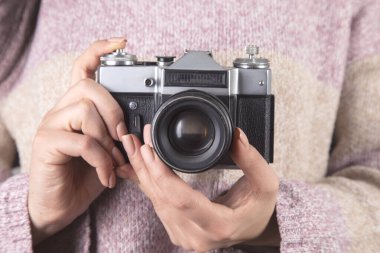 Klasik fotoğraf makinesini tutan genç bir kadın..