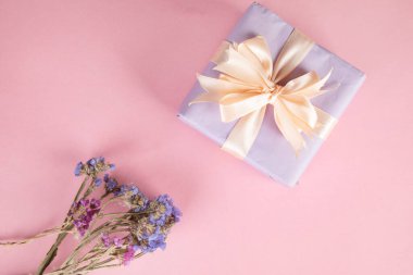 Pembe arka planda çiçekli hediye kutusu