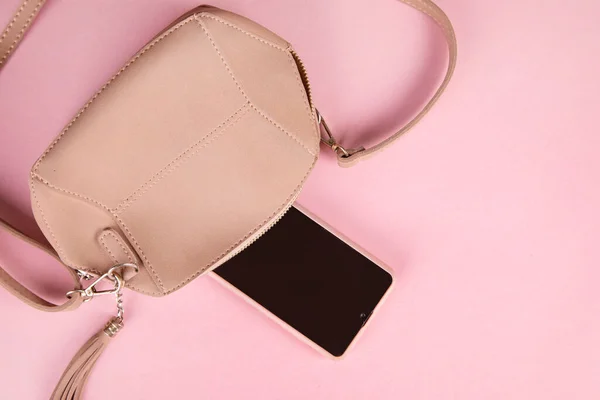 pink bag with smartphone on pink background