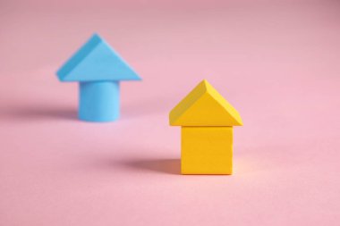 Pembe arka planda ev modeli olan küpleri