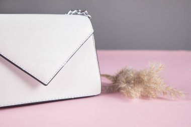 Masanın üzerinde çimen olan beyaz bir çanta.