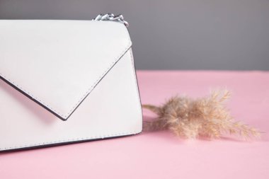 Masanın üzerinde çimen olan beyaz bir çanta.