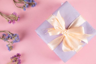 Masada mor çiçekli hediye kutusu.