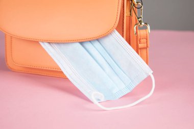 Pembe masadaki tıbbi maskeli çanta.