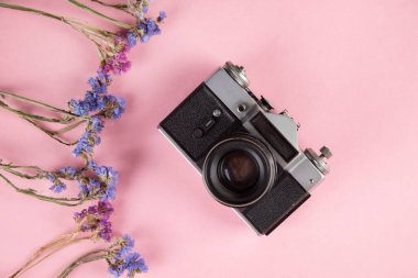 Masasında renkli çiçekler olan klasik kamera.