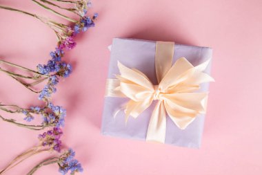 Masada hediye kutusu olan kurumuş renkli çiçekler.