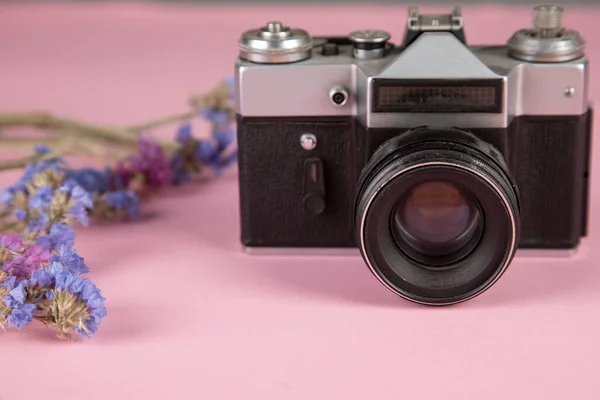 vintage camera with color flowers on table