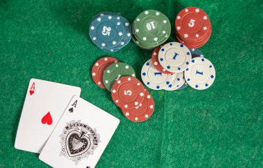 Yeşil masada çipleri olan poker asları.