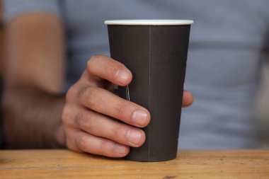 Elinde bir fincan kahve tutan adam. 