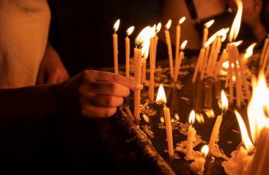 İnsanlar kilisede mum yakıyor..