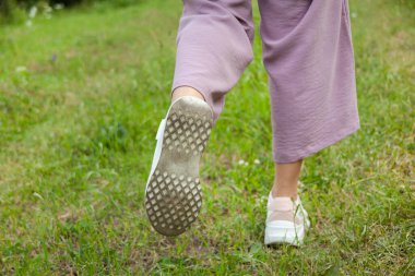 Yeşil doğada yürüyen genç bir kadın