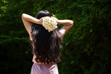 Elinde papatya buketi tutan genç bir kadın.