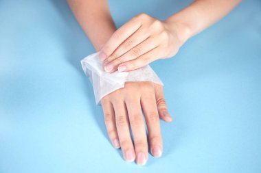 Kadın masanın üstünde peçeteyle ellerini temizliyor.