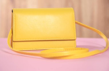 Sarı çanta pembe masa arkasında.