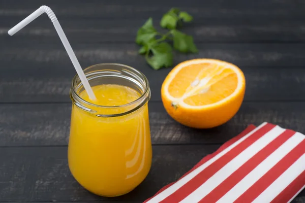 Suco de laranja fresco em um frasco de vidro com um tubo de plástico, meio O — Fotografia de Stock