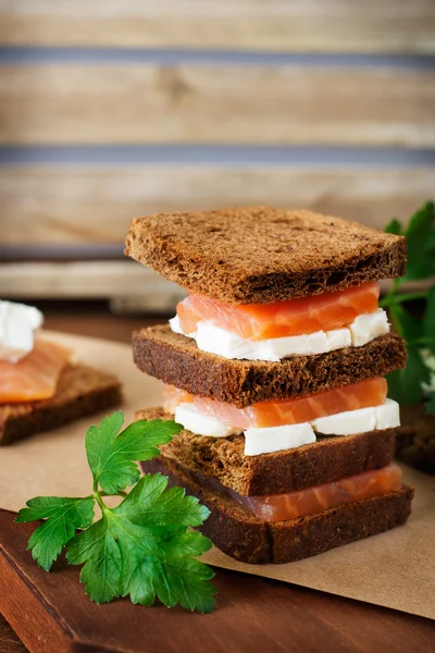 Lachssandwich auf rustikalem Holzhintergrund — Stockfoto