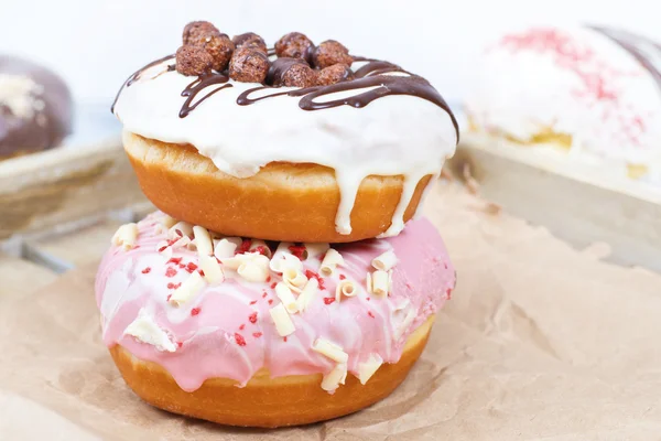 Donuts on Paper, Wooden background. — Stock Photo, Image