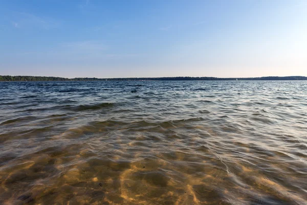 Mavi bulutlu gökyüzü altında göl