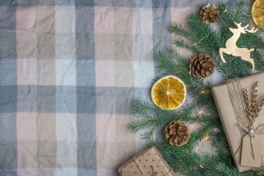 Altın harflerle ve geyiklerle dolu ahşap bir arka planda Noel kompozisyonu var. Yukarıdan manzara. Mutlu yıllar ve mutlu Noeller..