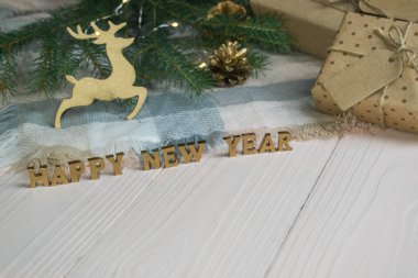 Ahşap bir arka planda Noel kompozisyonu ve yazı için altın harfler. Mutlu yıllar ve mutlu Noeller..