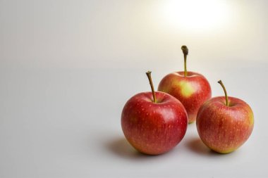 Beyaz arka planda üç kırmızı elma. Meyve. Hasat et.