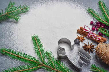 Minimalizm. Keskin bir kurabiye kesicisi ve ağacın bir dalının olduğu Noel arka planında mesaj yazılacak bir yer var. Üst Görünüm Düz Düzeni