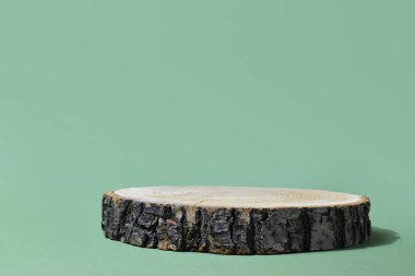 Ürün sunumu için podyum. Devrilmiş bir ağacın minimalist bir sahnesi yeşil bir zemine dayanır. Markalaşma için ön koşullar.
