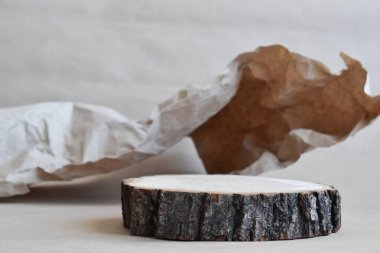 Ürün sunumu için podyum. Kırışmış kağıdın arka planına karşı kesilmiş bir ağacın minimalist bir sahnesi. Markalaşma için ön koşullar. Doğal arkaplan.