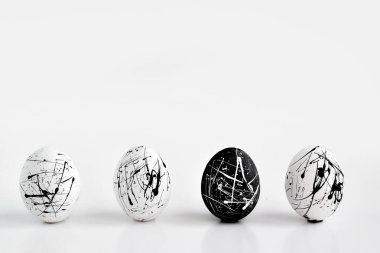 Üç beyaz yumurta ve bir siyah benekli yumurta. Paskalya. Minimalizm. Liderlik kavramı.