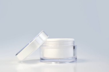 Krem, maske ve önlük için boş bir kavanozun tasarımı. Beyaz arka planda bir kavanoz krema. Kozmetik ve parfümler. Spa tedavileri. Markalaşma ve ürün sunumu için bir yer.