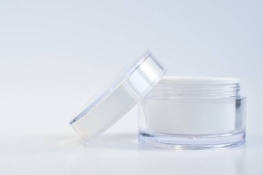 Krem, maske ve önlük için boş bir kavanozun tasarımı. Beyaz arka planda bir kavanoz krema. Doğal kozmetik ürünleri ve parfümler. Spa tedavileri. Markalaşma ve ürün sunumu için bir yer.