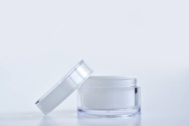 Krem, maske ve önlük için boş bir kavanozun tasarımı. Beyaz arka planda bir kavanoz krema. Doğal kozmetik ürünleri ve parfümler. Spa tedavileri. Markalaşma ve ürün sunumu için bir yer.