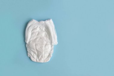 Açık mavi arka planda bebek bezi ve boşluğun bir kopyası. Bebekler için hijyen. Çocuk bakımı
